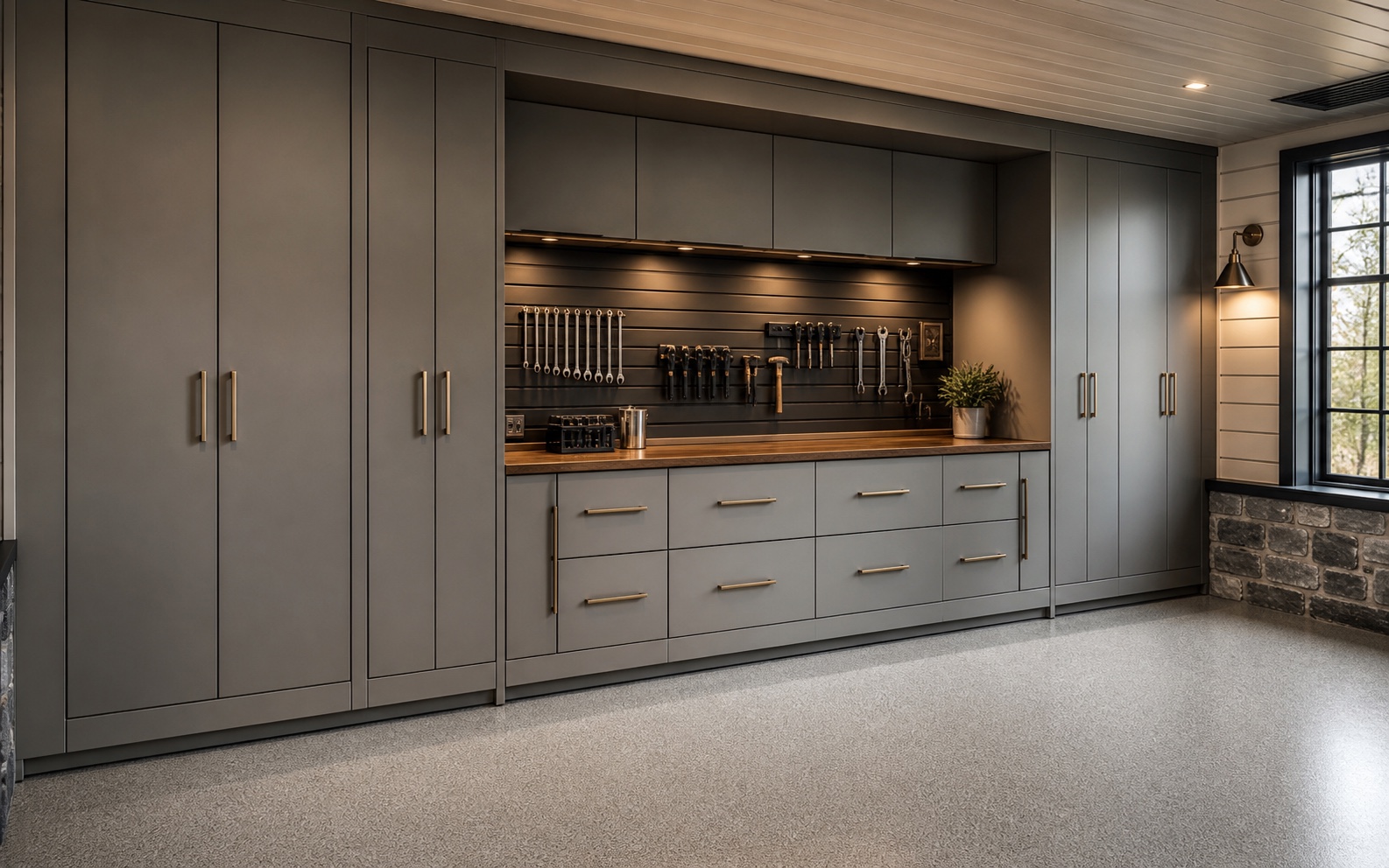 Finished garage with coordinated graphite cabinets, workbench, slatwall, and clear vehicle space