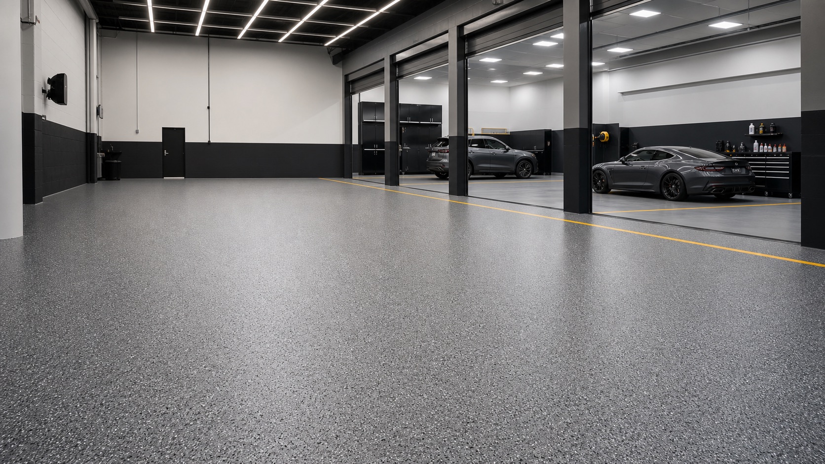 Large professionally coated garage floor with clean reflective finish and organized service bays